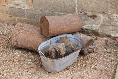 A Small Metal Tub Holding Firewood Logs.