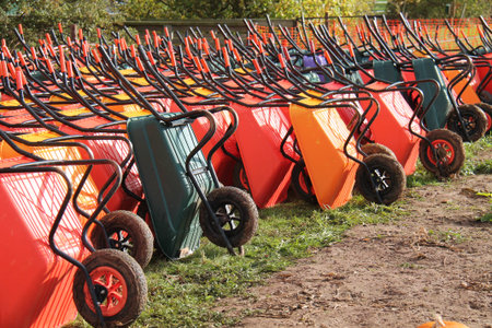 Large Collection of Coloured Plastic Garden Wheelbarrows.