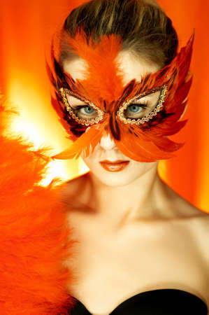 Portrait of attractive beautiful young woman wearing red carnival maskの写真素材