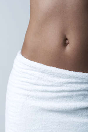 Beautiful womans body part wearing white towel on clear backgroundの写真素材