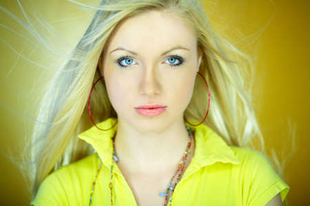 Portrait of beautiful blond woman wearing yellow shirtの写真素材