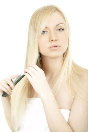 Portrait of Fresh and Beautiful young blond woman brushing her hairの写真素材