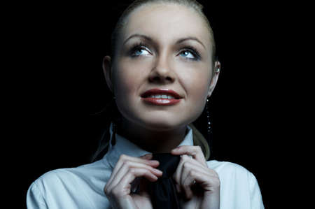 Beautiful business woman wearing black tie and white shirt isolated on black backgroundの写真素材