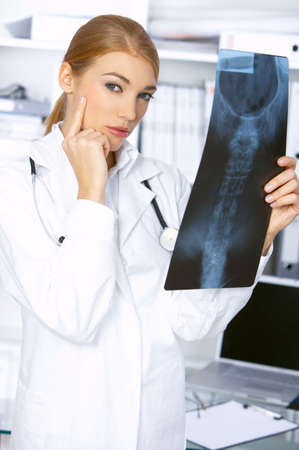 Thinking female doctor and examining x-ray picture