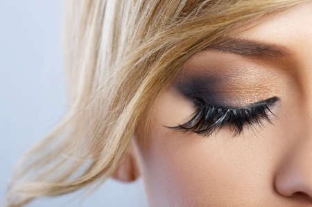 Beautiful blond woman with artistic feather makeup
