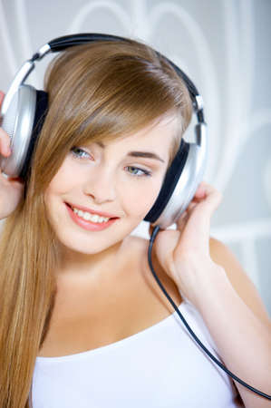 Portrait of cute teenage girl is listening musicの写真素材