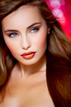 Portrait of beautiful young sexy woman on red backgroundの写真素材