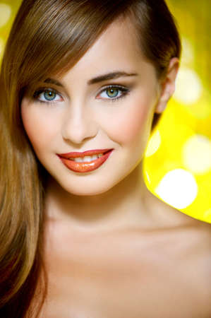 Portrait of beautiful young sexy woman on yellow backgroundの写真素材