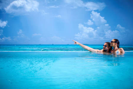 Romantic couple alone in infinity swimming pool