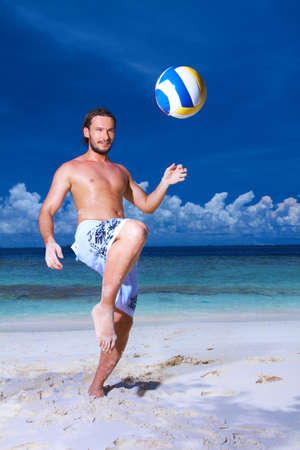 Handsome man is playing on the beach wearing finの写真素材