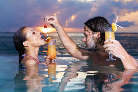 Romantic couple alone in infinity swimming poolの写真素材