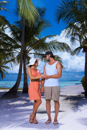 Romantic couple standing next to palm treeの写真素材