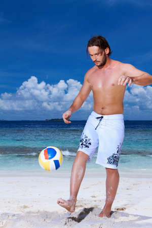 Handsome man is playing on the beachの写真素材
