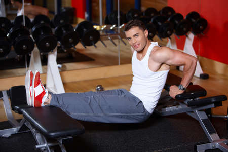 Handsome man at the gym doing exercisesの写真素材