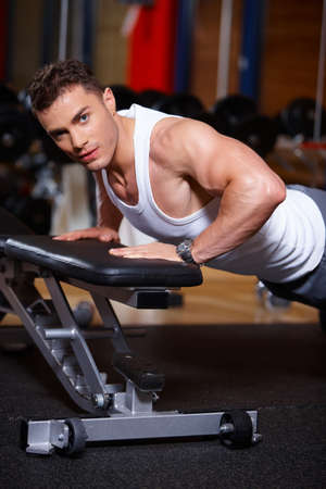 Handsome man at the gym doing exercisesの写真素材