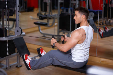 Handsome man at the gym doing exercisesの写真素材