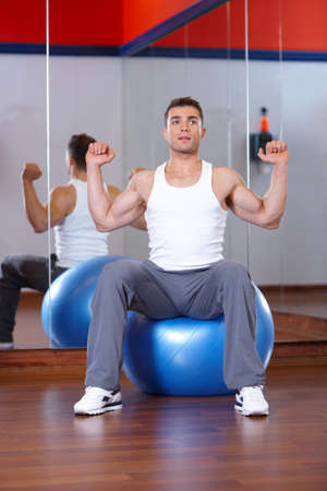 Handsome man at the gym doing exercisesの写真素材