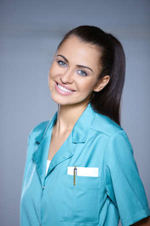 Portrait of beautiful female doctor on gray backgroundの写真素材