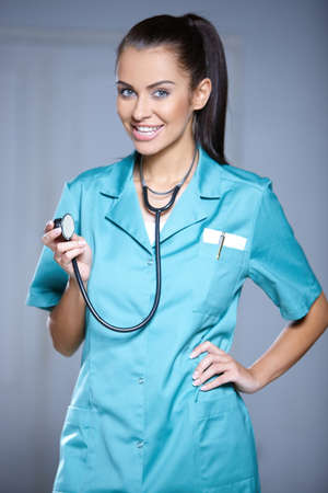 Portrait of beautiful female doctor on gray backgroundの写真素材