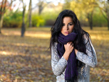 Beautiful woman spending time in park during autumn seasonの写真素材