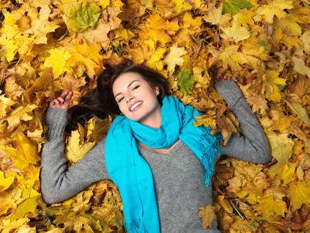 Beautiful woman spending time in park during autumn seasonの写真素材