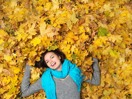 Beautiful woman spending time in park during autumn seasonの写真素材