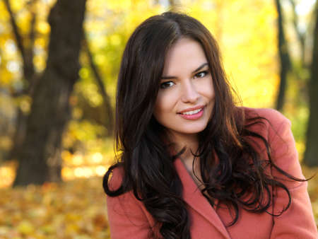 Beautiful woman spending time in park during autumn seasonの写真素材