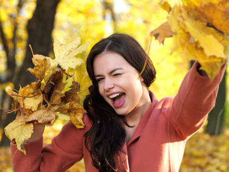 Beautiful woman spending time in park during autumn seasonの写真素材