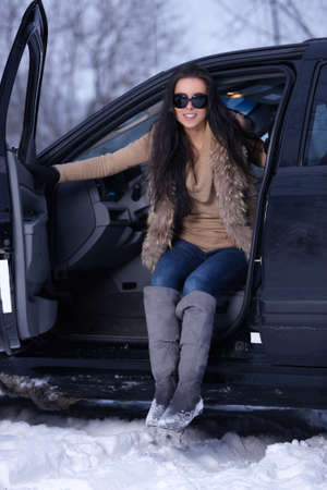 Beautiful woman in car in snowy winter outdoorsの写真素材