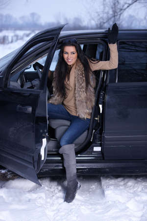 Beautiful woman in car in snowy winter outdoorsの写真素材