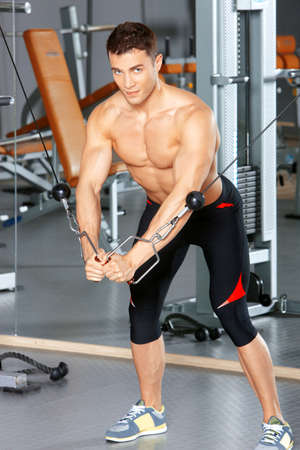 Handsome man at the gym doing exercisesの写真素材