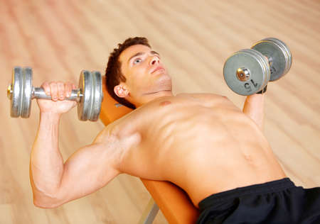 Handsome man at the gym doing exercisesの写真素材