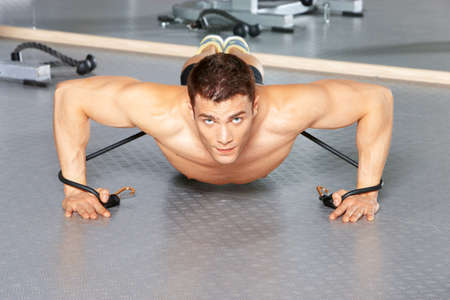 Handsome man at the gym doing exercisesの写真素材