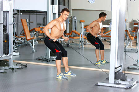 Handsome man at the gym doing exercisesの写真素材