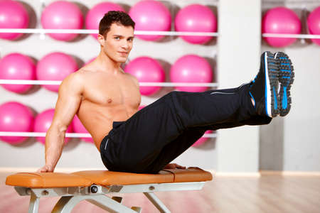 Handsome man at the gym doing exercisesの写真素材