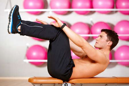 Handsome man at the gym doing exercisesの写真素材