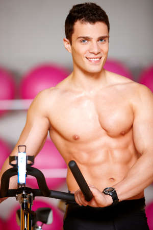 Handsome man at the gym doing exercisesの写真素材