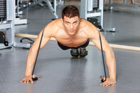 Handsome man at the gym doing exercisesの写真素材