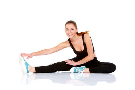 Beautiful fitness woman doing stretching exercise on whiteの写真素材