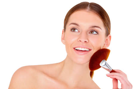 Portrait of beautiful young woman with makeup brush on whiteの写真素材