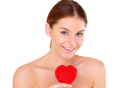 Portrait of beautiful young woman with red heart on whiteの写真素材