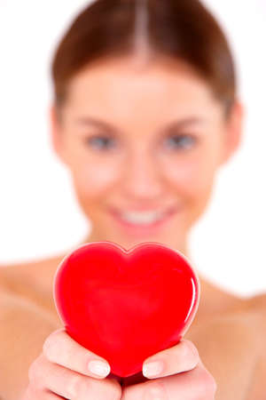 Portrait of beautiful young woman with red heart on whiteの写真素材