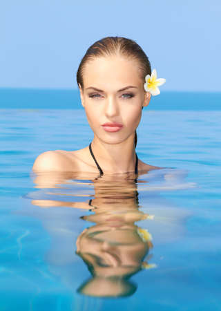 Cute blond girl relaxing in swimming poolの写真素材