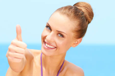 Portrait of happy woman with thumb up gestureの写真素材