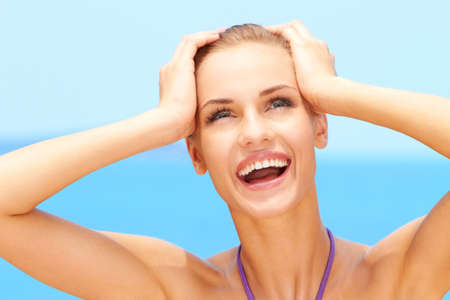 Happy young woman smiling while on the beach in her bikiniの写真素材