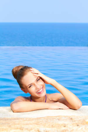 Close up of cute girl in infinity pool with copy spaceの写真素材
