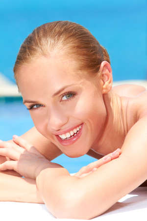 Close up of beautiful woman lying next to swimming poolの写真素材