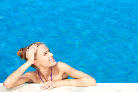 Cute girl in swimming pool looking at copy spaceの写真素材