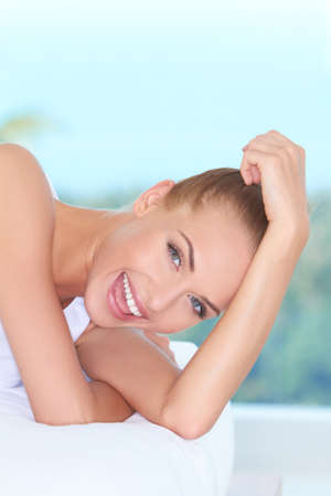 Closeup facial expression of a beautiful high-spirited woman laughing into the cameraの写真素材