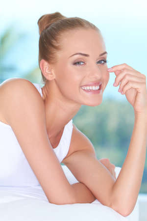 Closeup facial expression of a beautiful high-spirited woman laughing into the cameraの写真素材